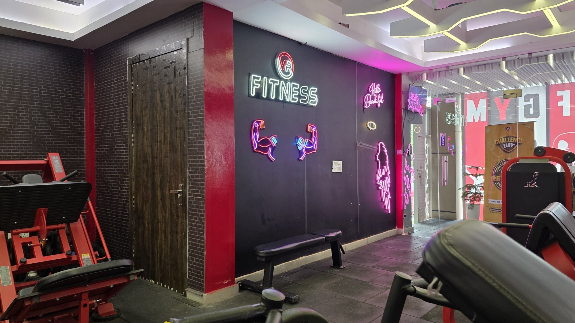 A compact strength corner with plate-loaded machines and a bench at a WTF gym