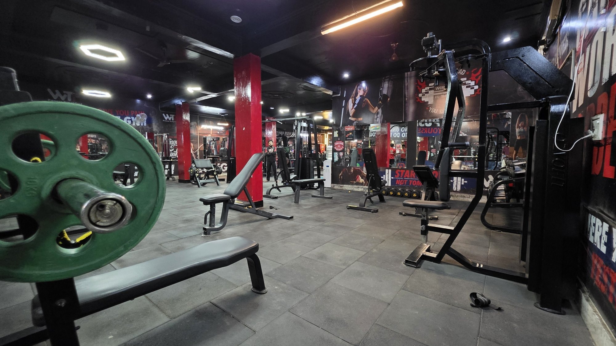 A weight plate and bench in the free-weight zone of a WTF gym