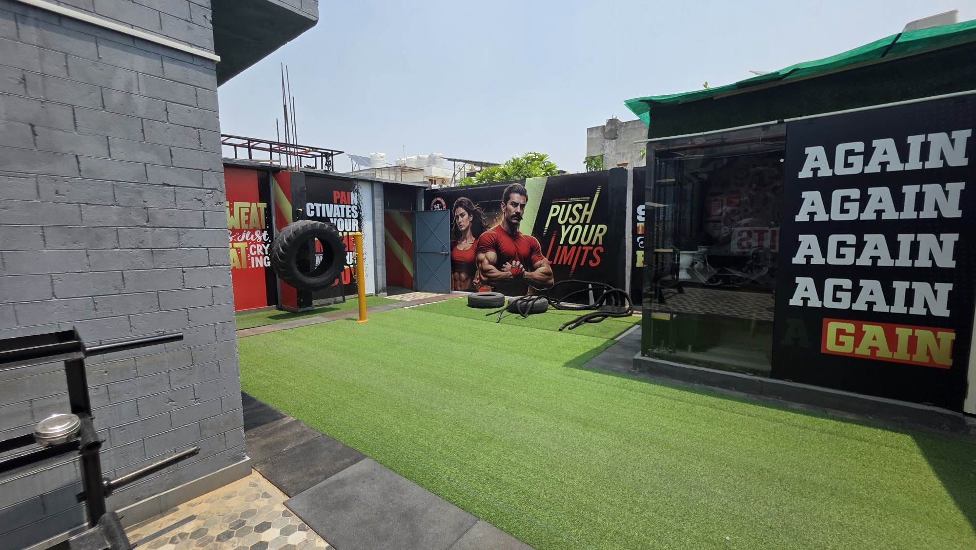 An open-air turf terrace with a training tyre at a WTF gym