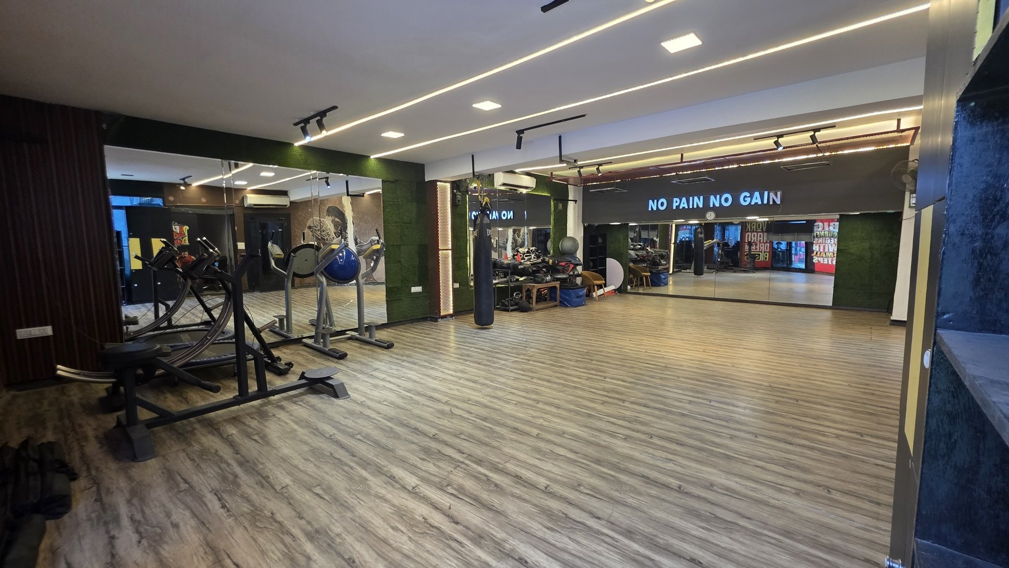 An open wooden-floored studio with an exercise ball and punching bag at a WTF gym