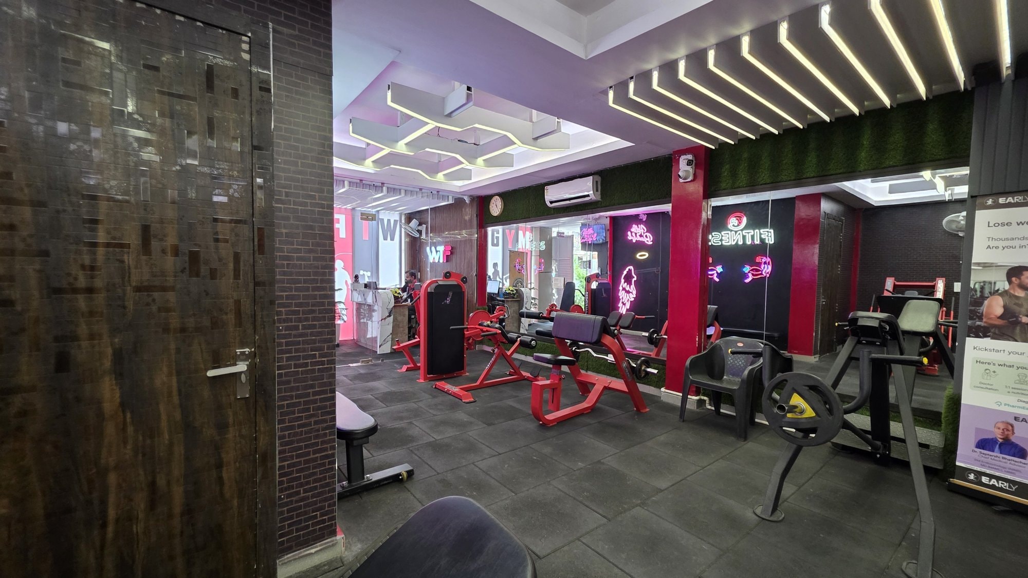 Red plate-loaded machines on the strength floor of a WTF gym