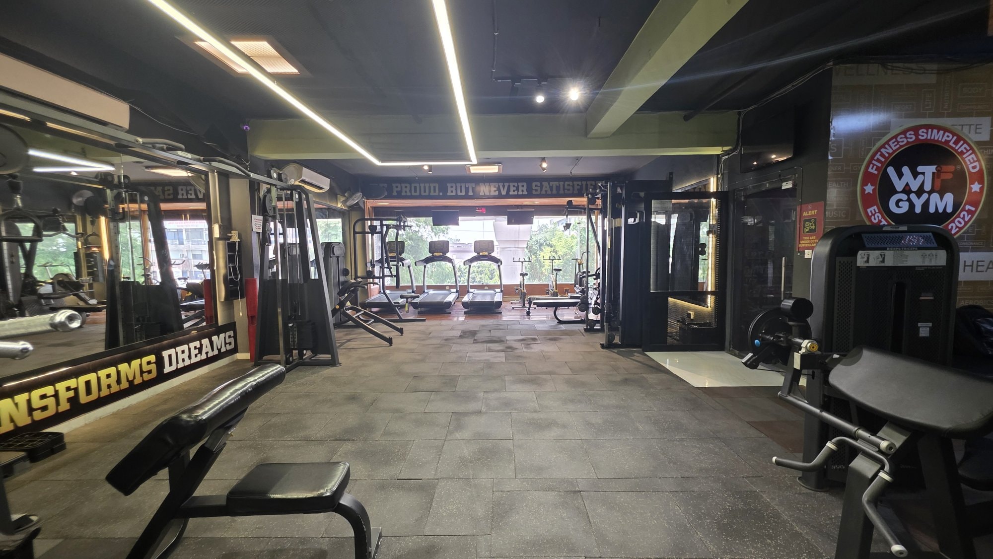 A strength floor leading to a treadmill line at a WTF gym
