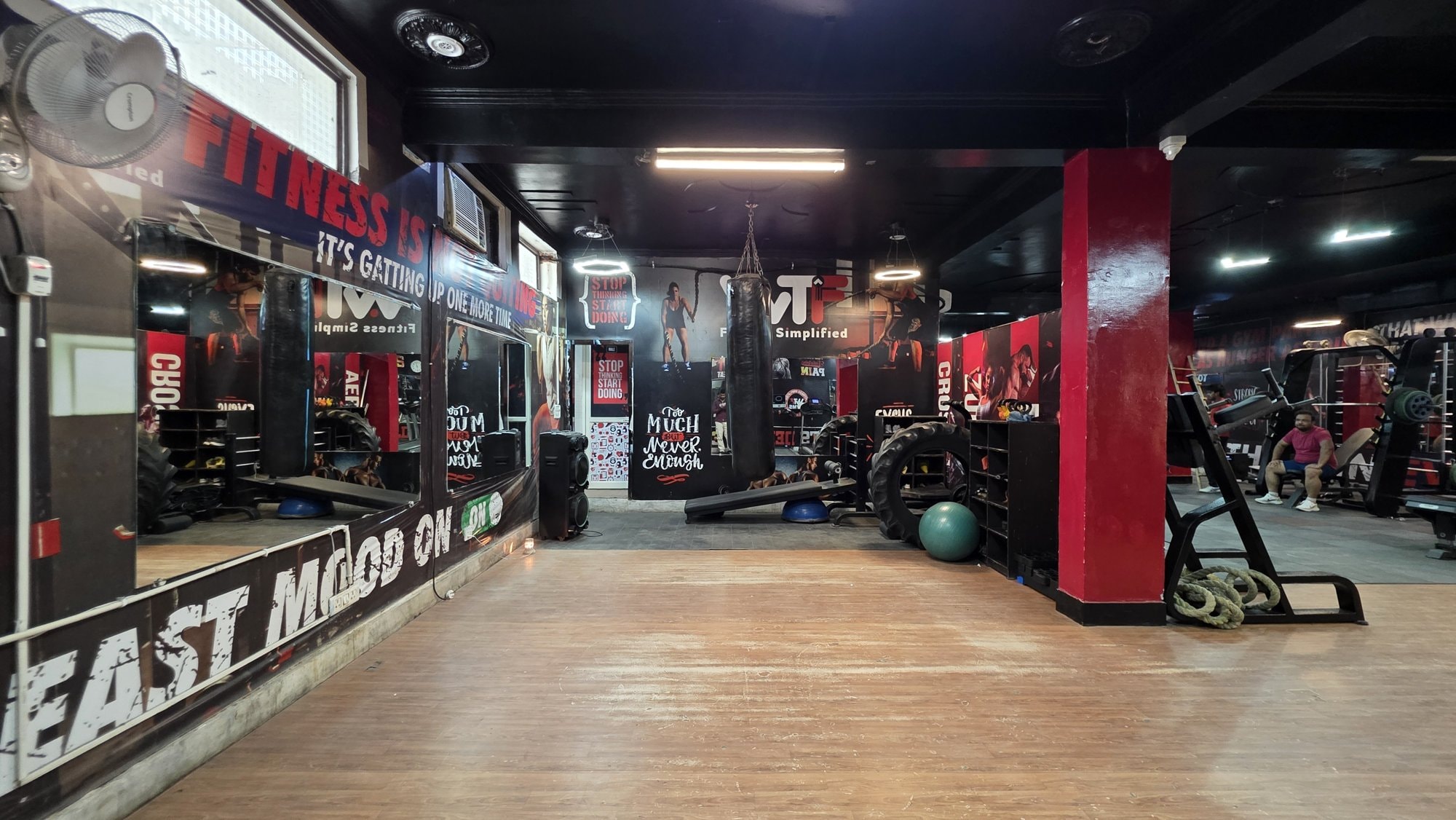 An open wooden-floored stretch area with an exercise ball at a WTF gym