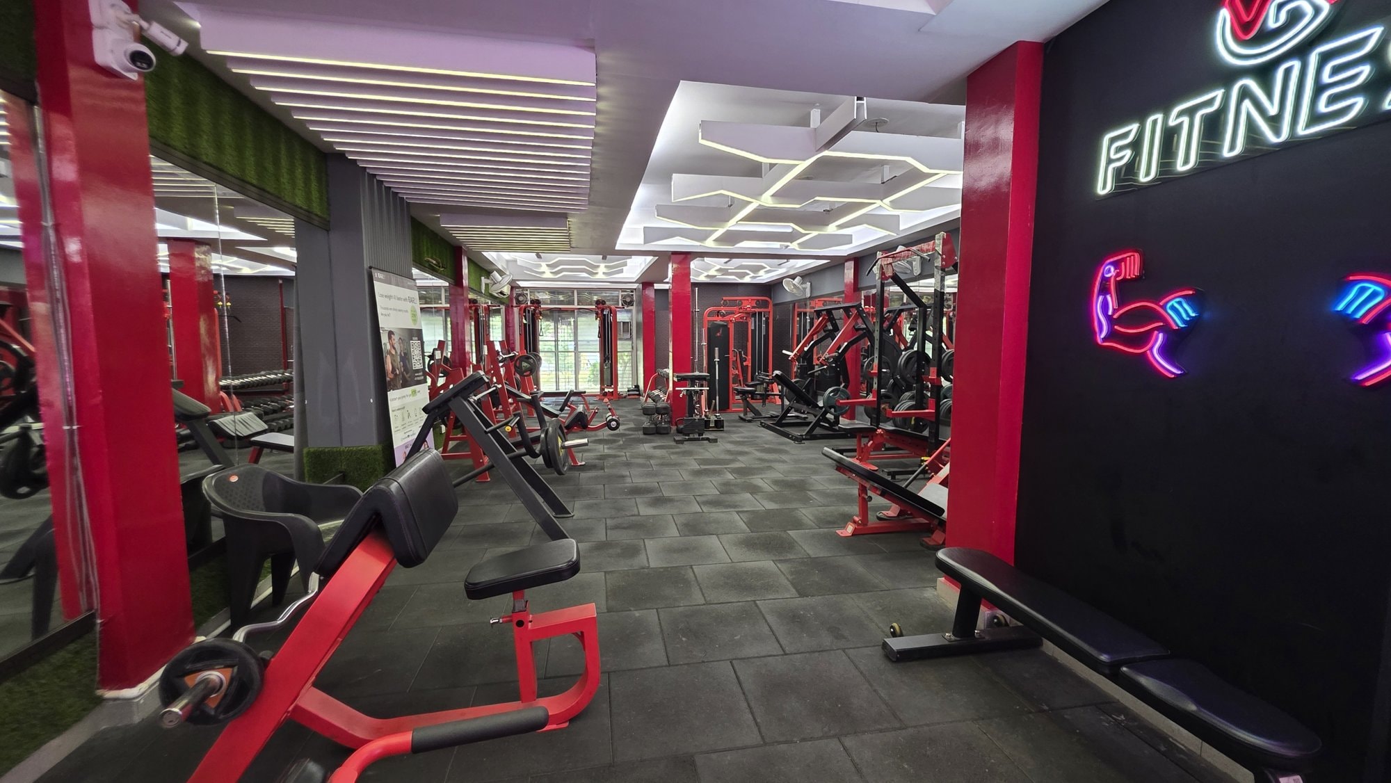 Red plate-loaded machines along the wall of a WTF gym