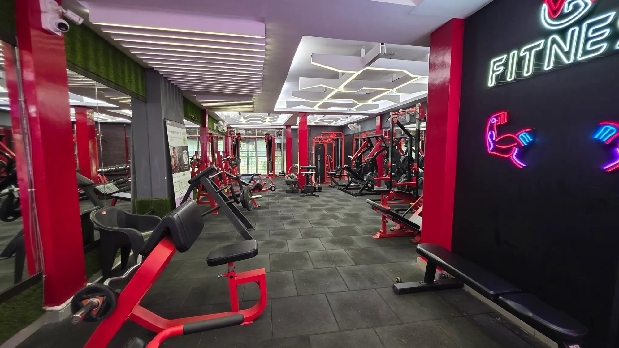 Red plate-loaded and bench equipment on the strength floor of a WTF gym